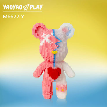 A split-color ​​Brick Bear toy​​ with coral pink and pearl white halves, crimson heart torso, and sun-to-azure gradient backdrop